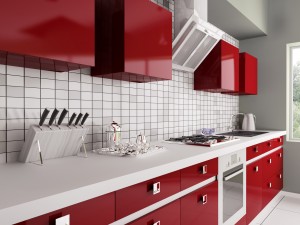Gloss red kitchen units with white worktop and tiled splashback